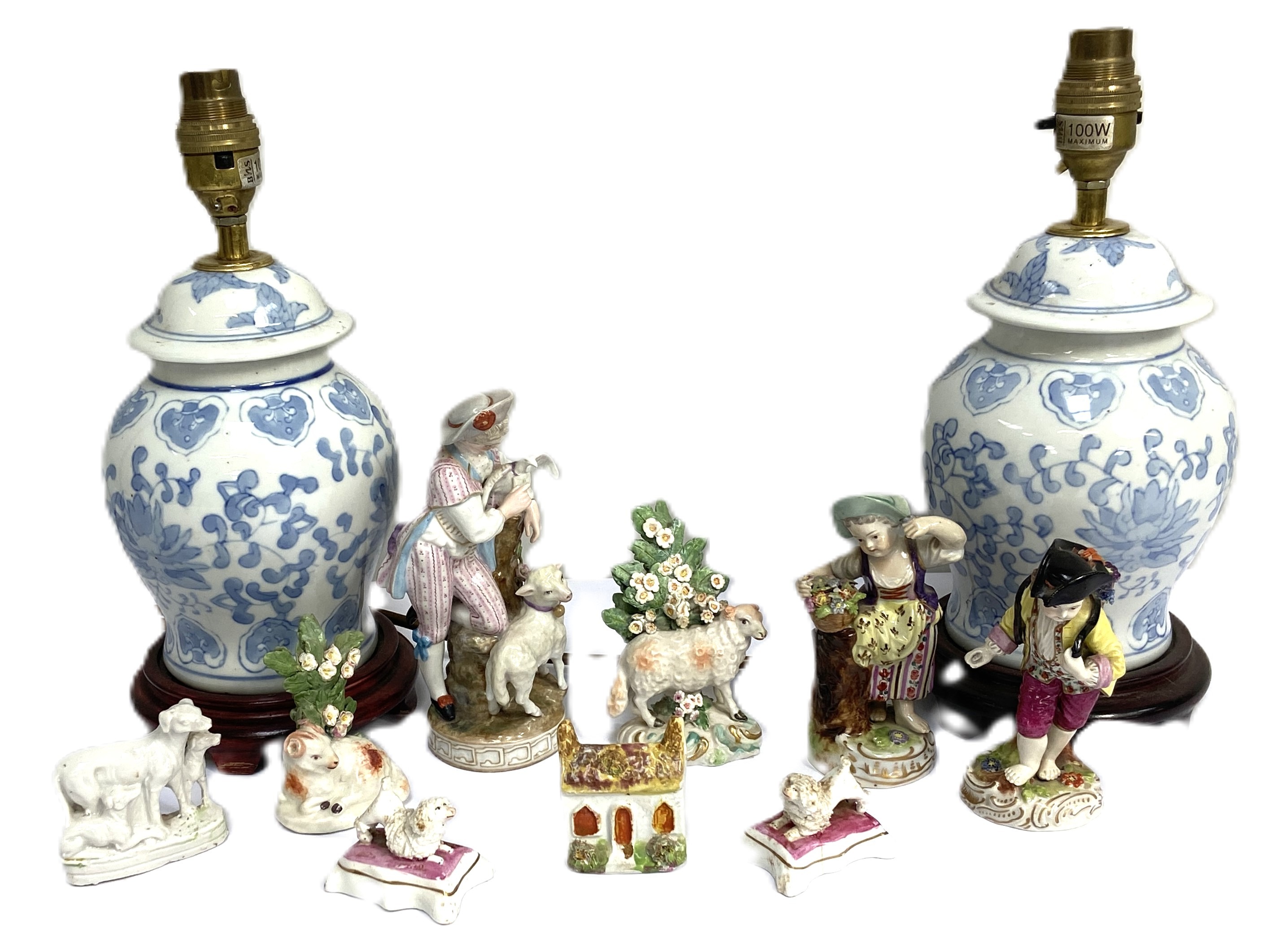 A small group of china figure groups, including two small figures of poodles on cushions; two