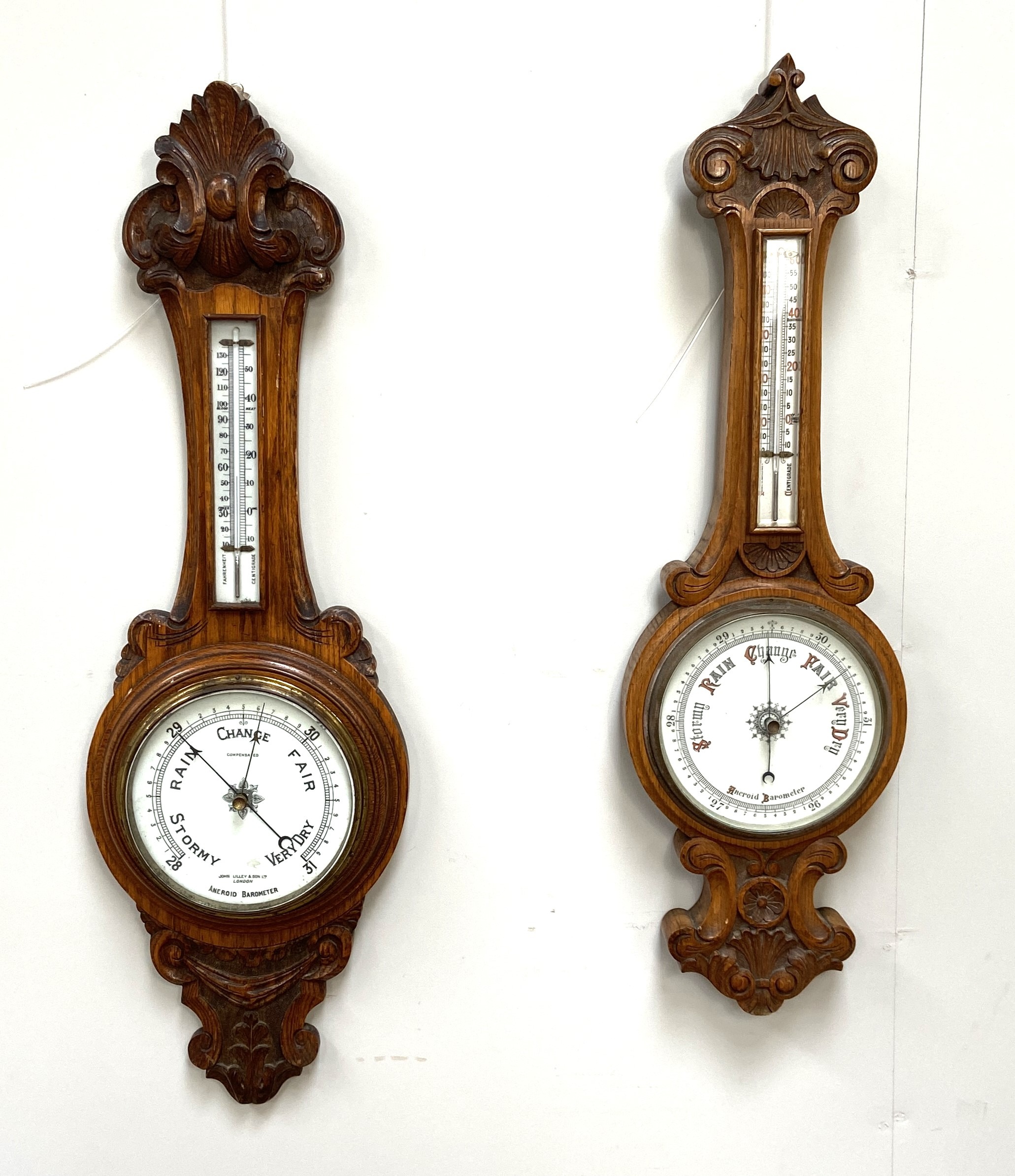 Two Victorian oak cased aneroid wall barometers, late 19th century, both with moulded and carved