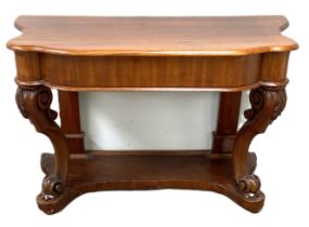 A Victorian mahogany console table, with shaped top and cabriole front legs and a platform