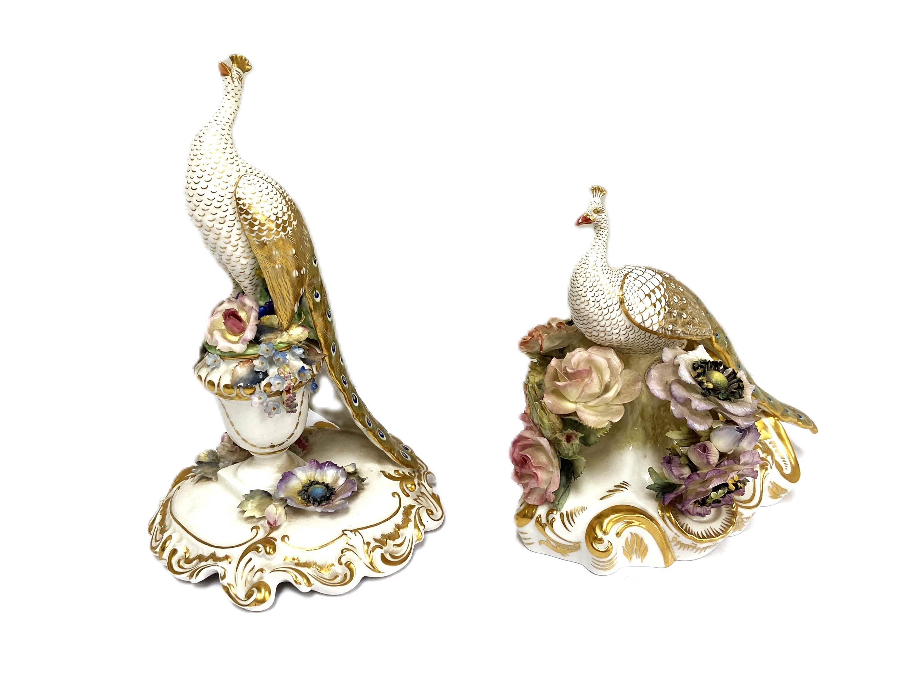 Royal Crown Derby, two figures of peacocks, both set on floral encrusted and gilt bases, decorated
