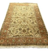 A modern Persian style wool mix carpet, with floral arabesques on a caramel ground, within guard