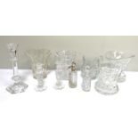 A collection of various cut glass jugs, a small pair of candlesticks, a flared vase and similar