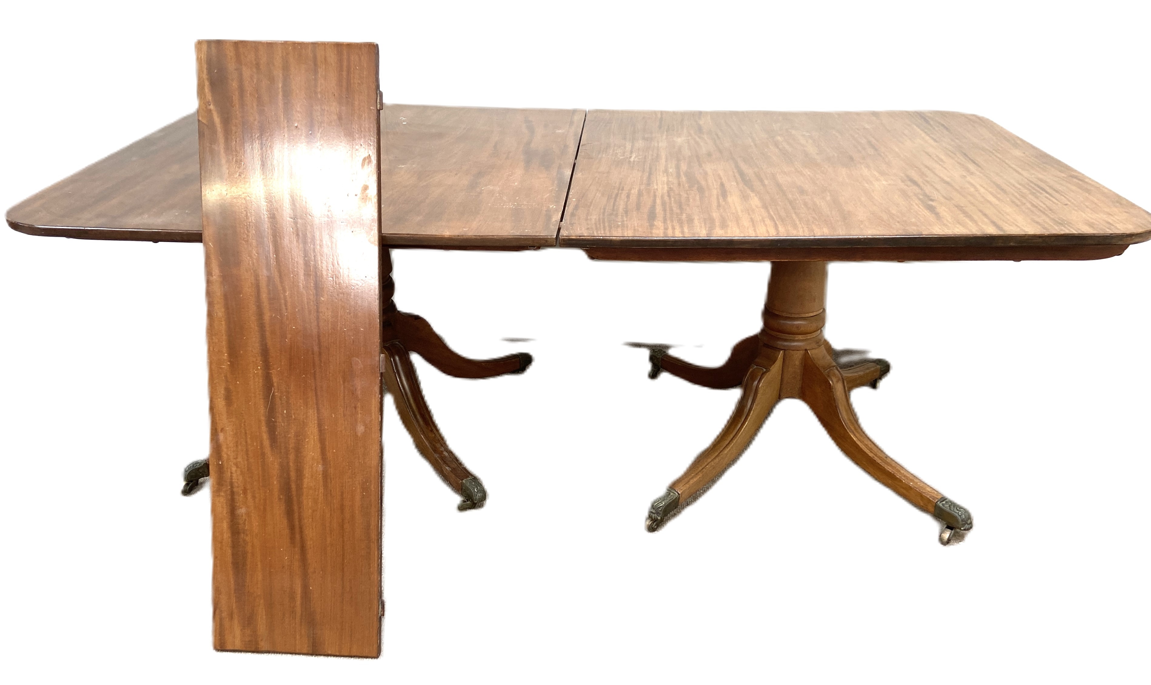 A George IV mahogany extending dining table, circa 1825, with an rounded rectangular top, with two