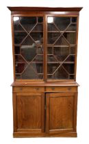 A Georgian style mahogany bookcase, with moulded cornice over two glazed bookcase doors, opening