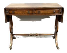 A Regency style mahogany veneer sofa table, with drop leaf top and Lyre end supports, 74cm high,