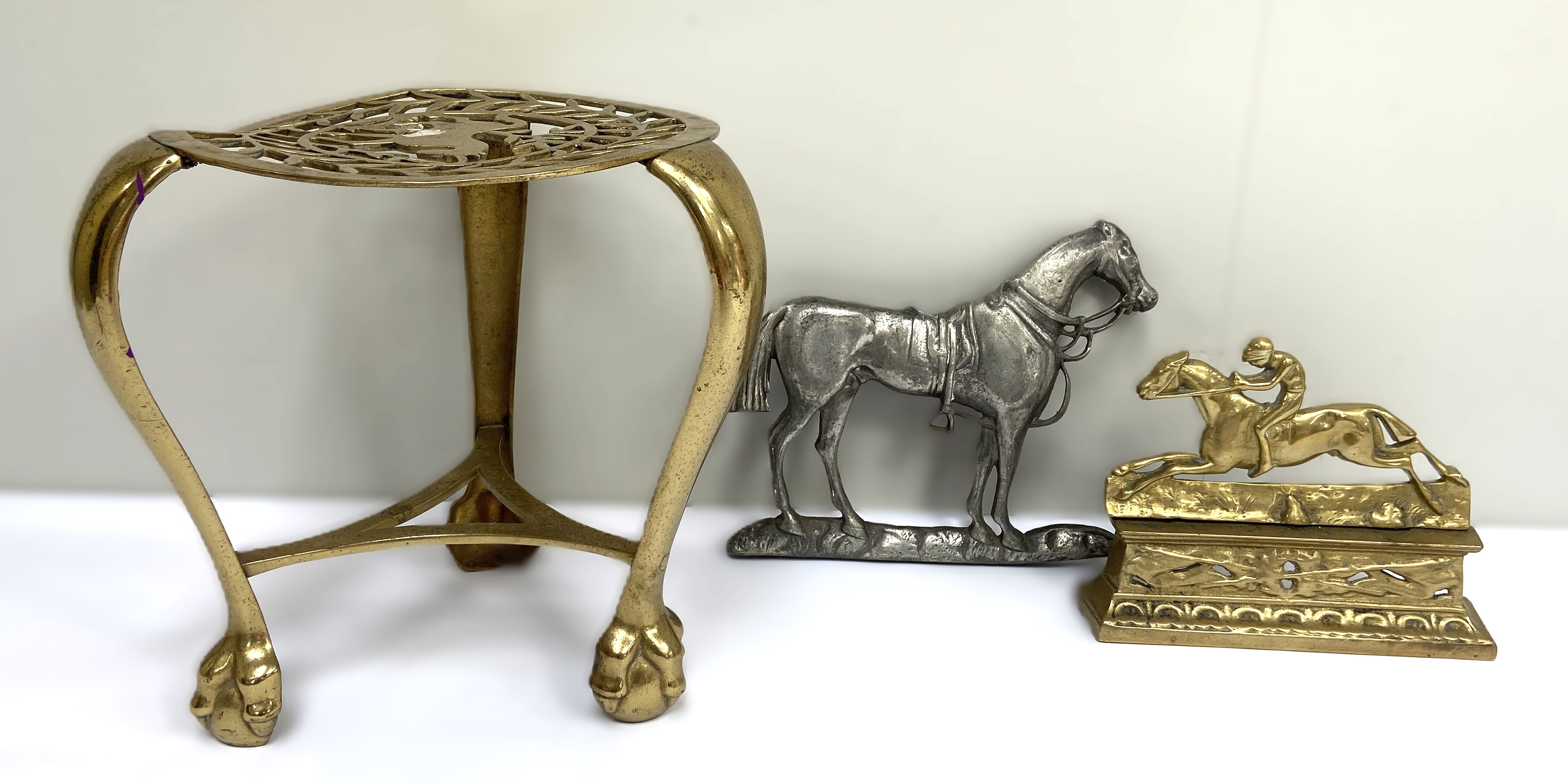 A 19th century brass horse mounting stool, with three legs and cented by a fretwork cut horse;