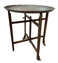 An embossed Islamic copper tray and associated folding stand, 72cm diameter; also a group of baskets