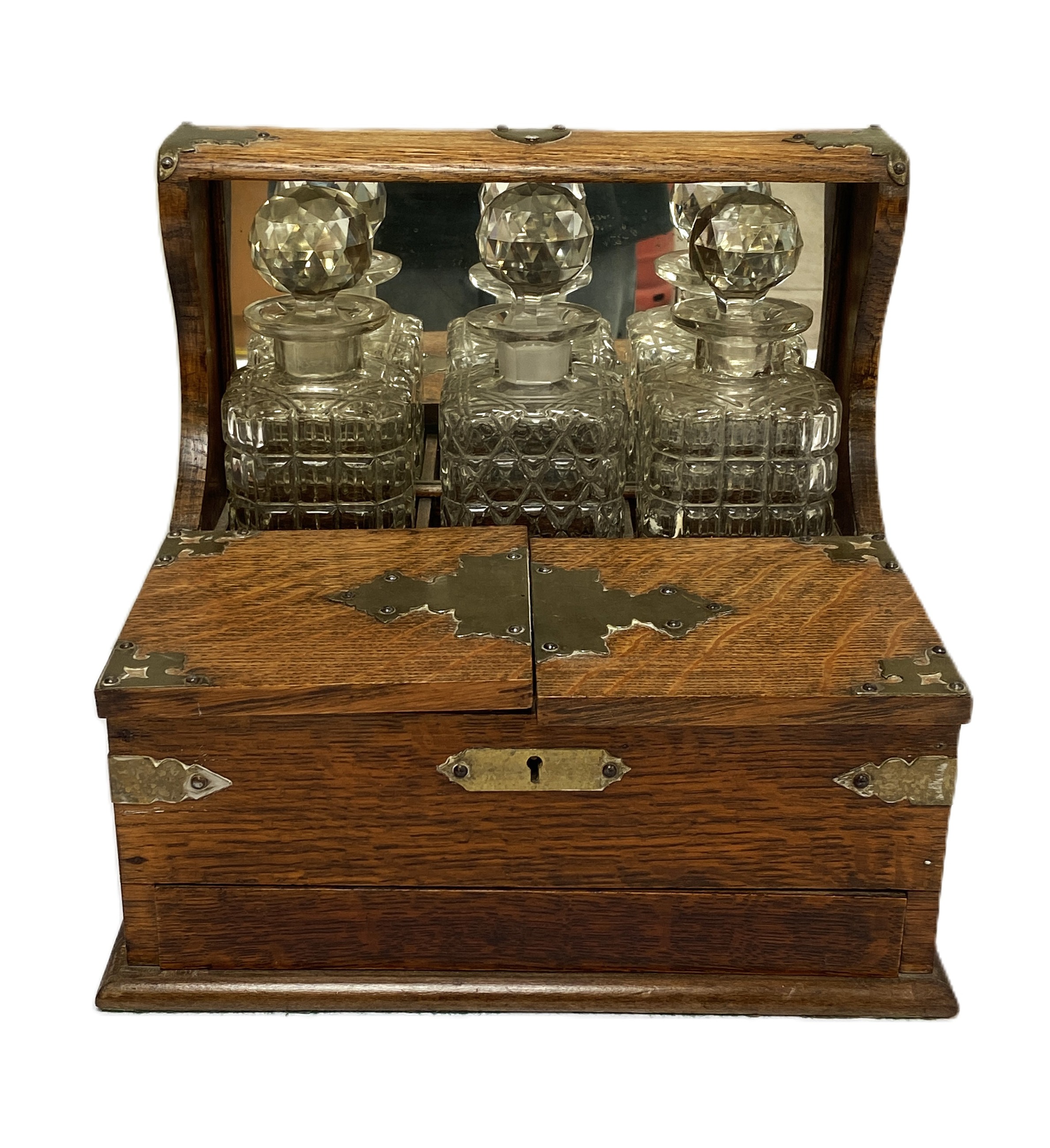 A Victorian oak cased tantalus, fitted with three spirit decanters, a humidor compartment and sprung