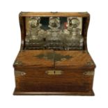 A Victorian oak cased tantalus, fitted with three spirit decanters, a humidor compartment and sprung