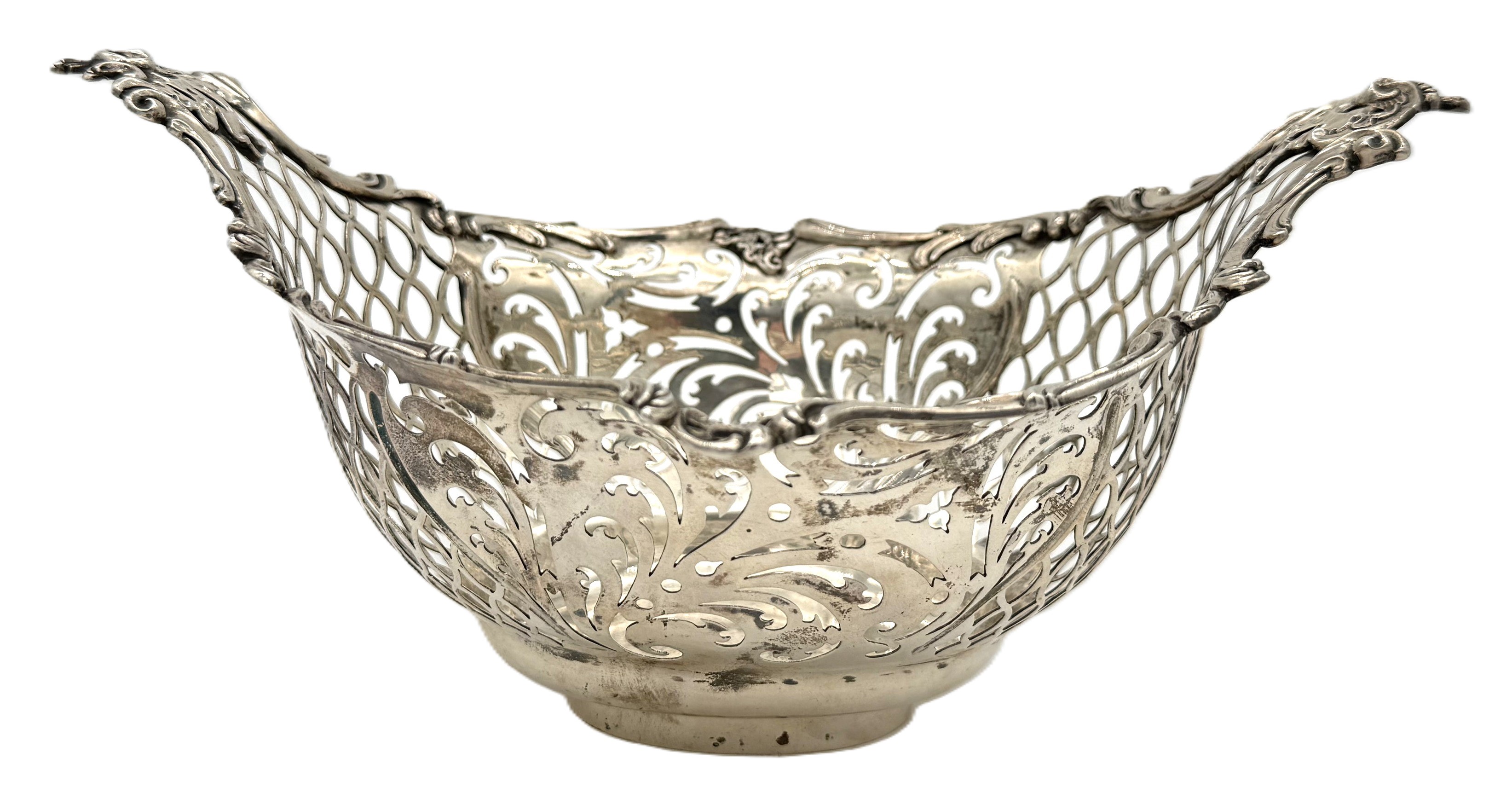 A George III silver bread basket, hallmarked London 1767, of oval deep dished form with scrolled rim