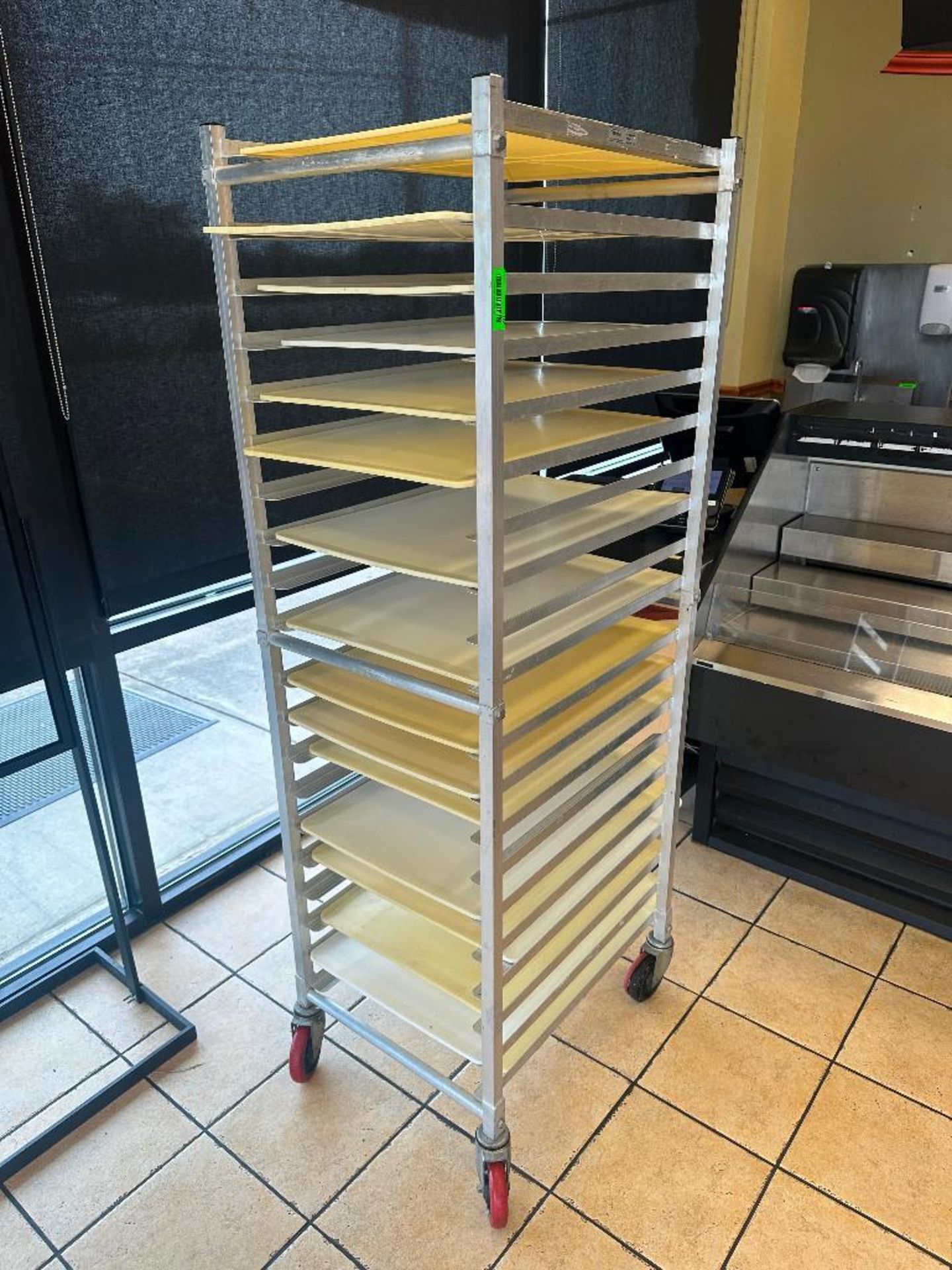 DESCRIPTION TWENTY PAN ROLL ABOUT TRAY RACK W/ CONTENTS - PLASTIC DOUGH BOARDS. LOCATION 7399 O'Conn