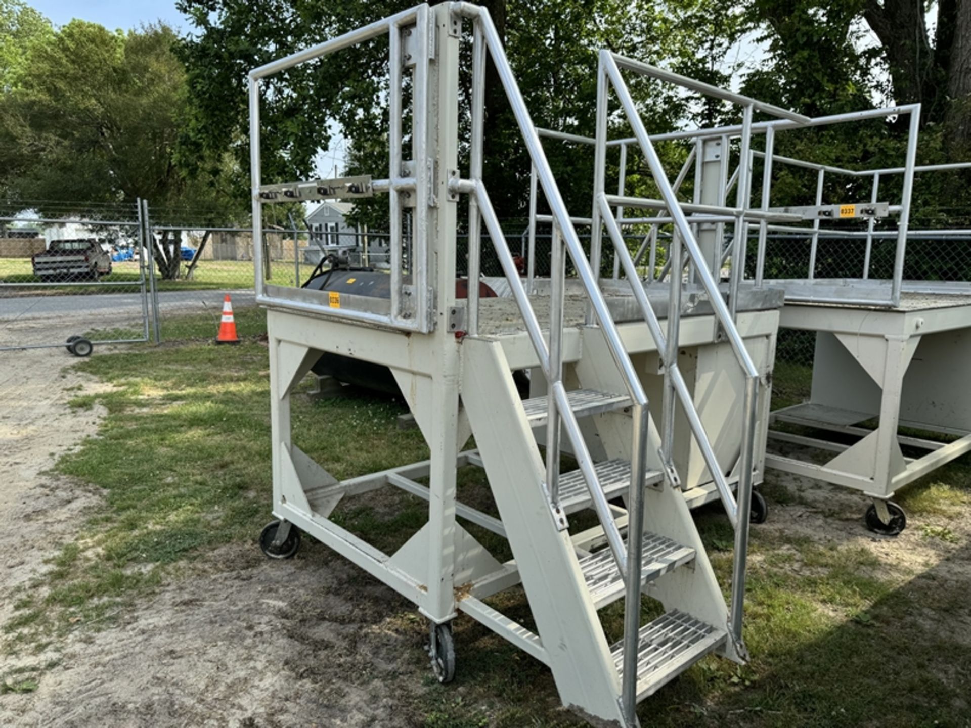 raised metal platform on wheels with guard rails