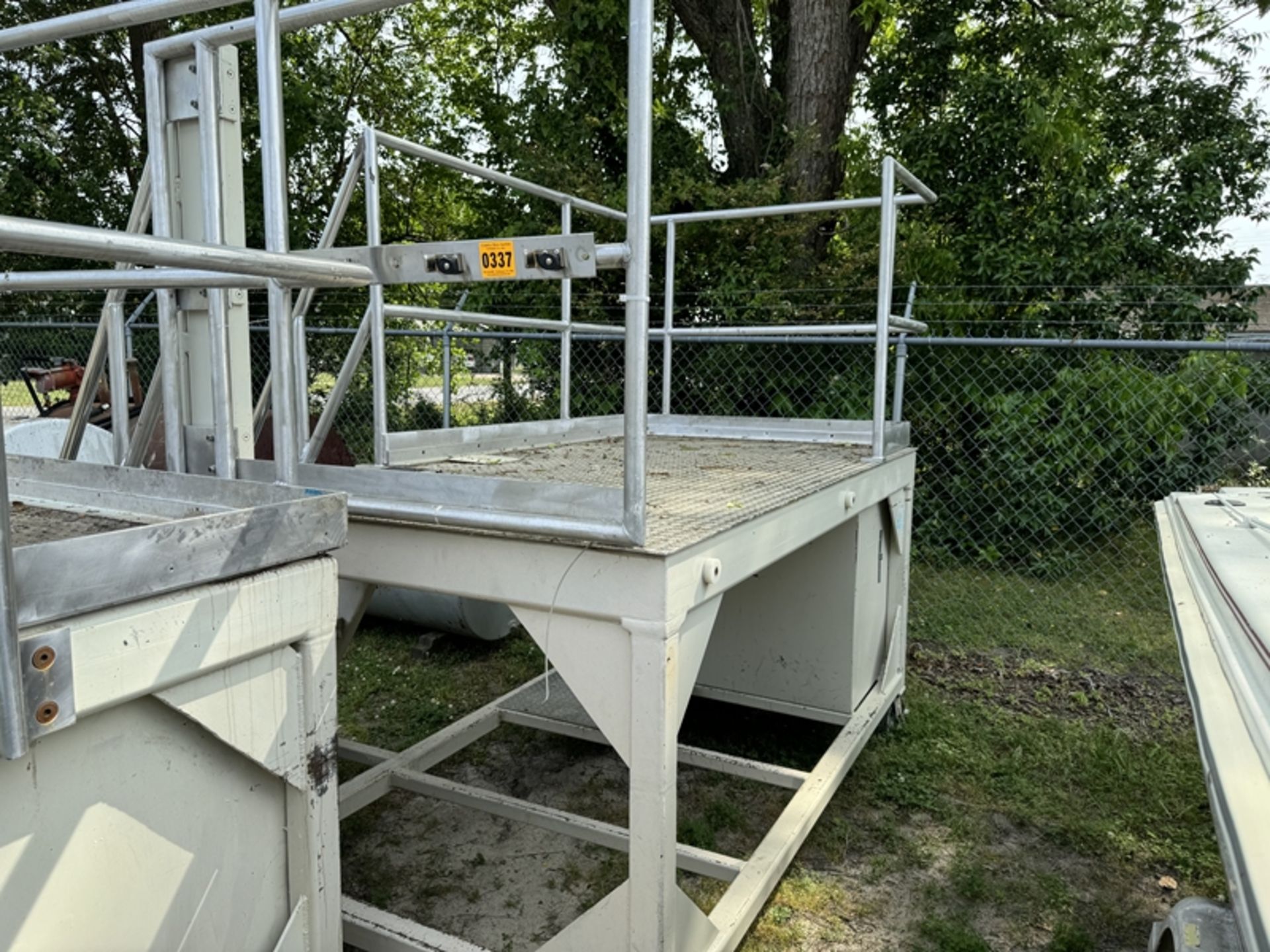 raised metal platform on wheels with guard rails