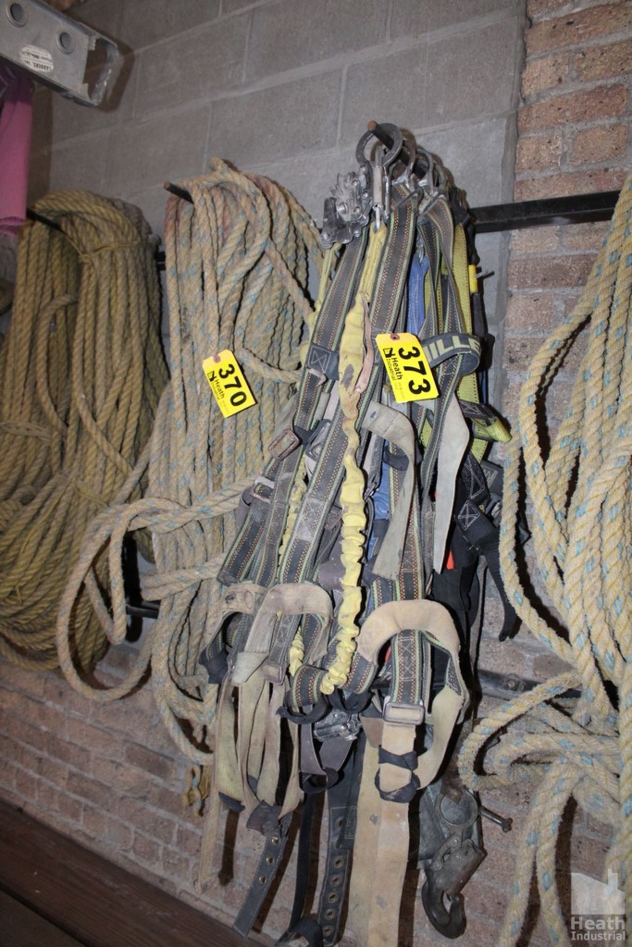 LARGE QUANTITY OF SAFETY HARNESSES ON WALL