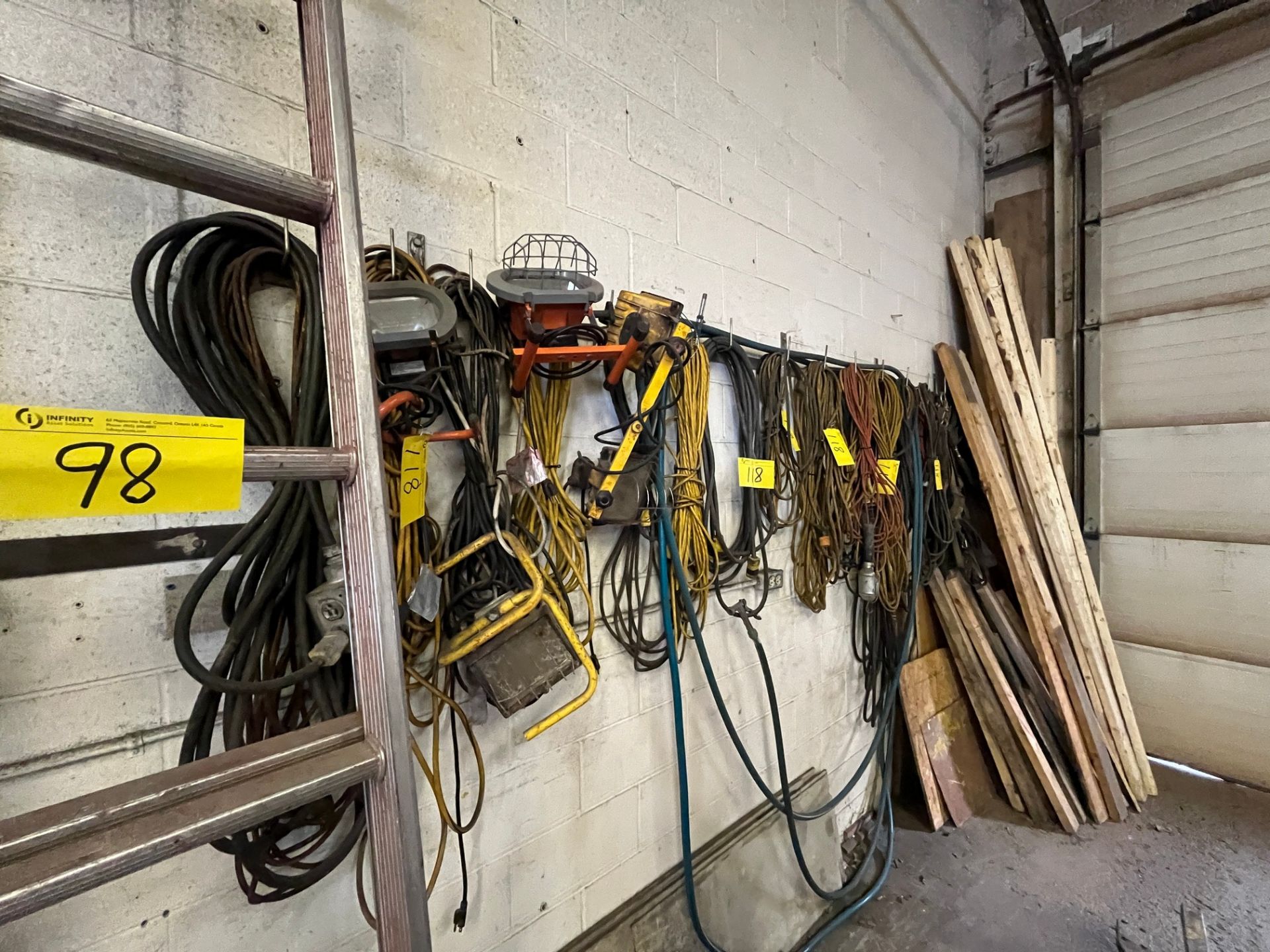 LOT OF HANGING EXTENSION CORDS AND RACK