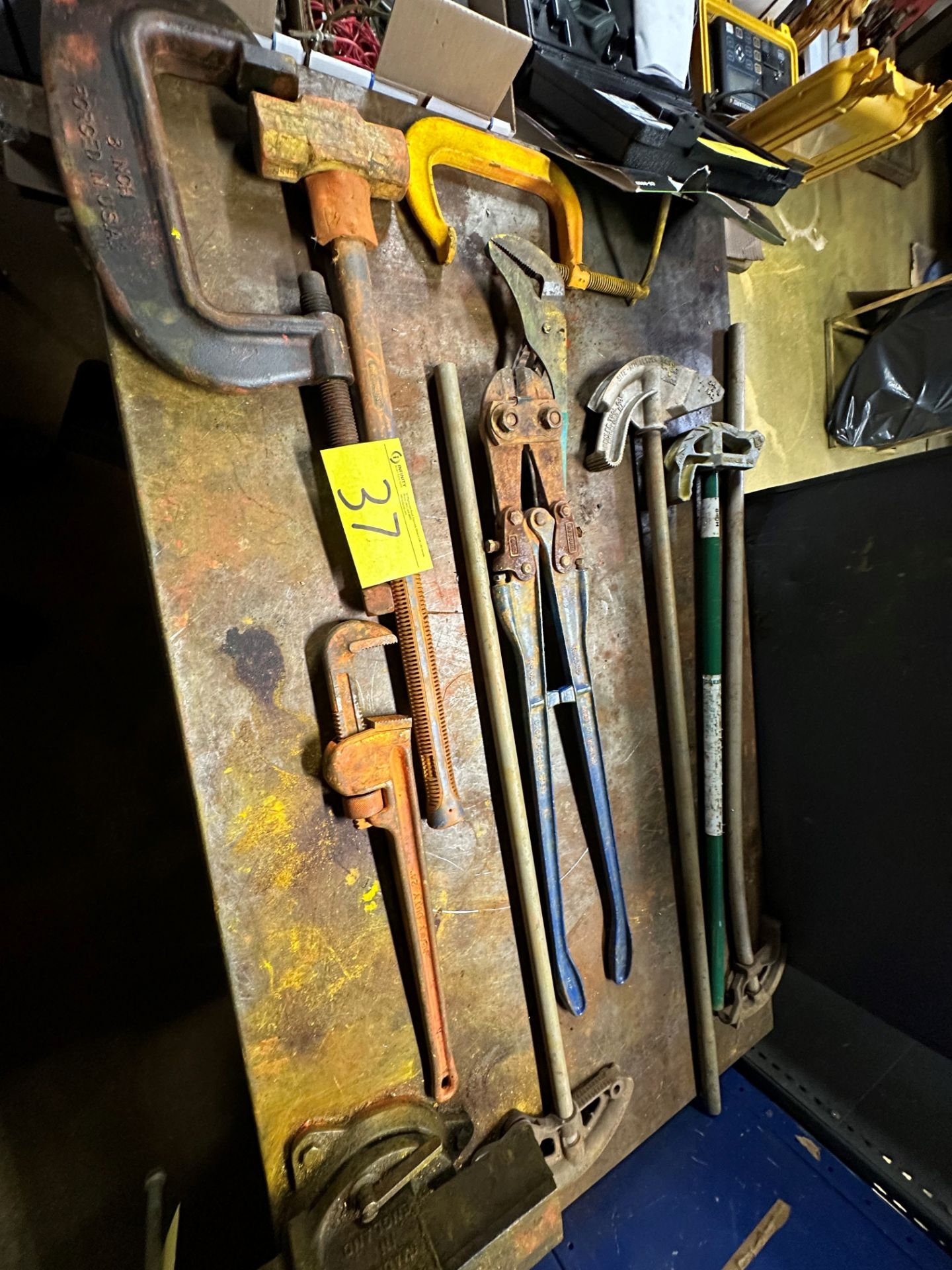LOT OF CONDUIT BENDERS, BOLT CUTTERS, SLEDGE HAMMER, PIPE WRENCHES, CHANNEL LOCK, C-CLAMPS ON TABLE