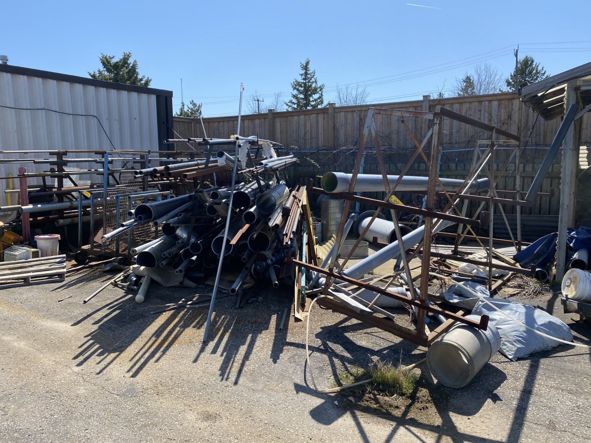 LOT OF (4) METAL STORAGE RACKS W/ PIPE AND CONTENTS (METAL AND PLASTIC), BATTERY ROLLER TRAY, ETC.