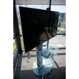 65" VIZIO TV WITH METAL AND GLASS STAND WITH REMOTE AND APPLE TV AND REMOTE, STREAMING CAMERA FOR