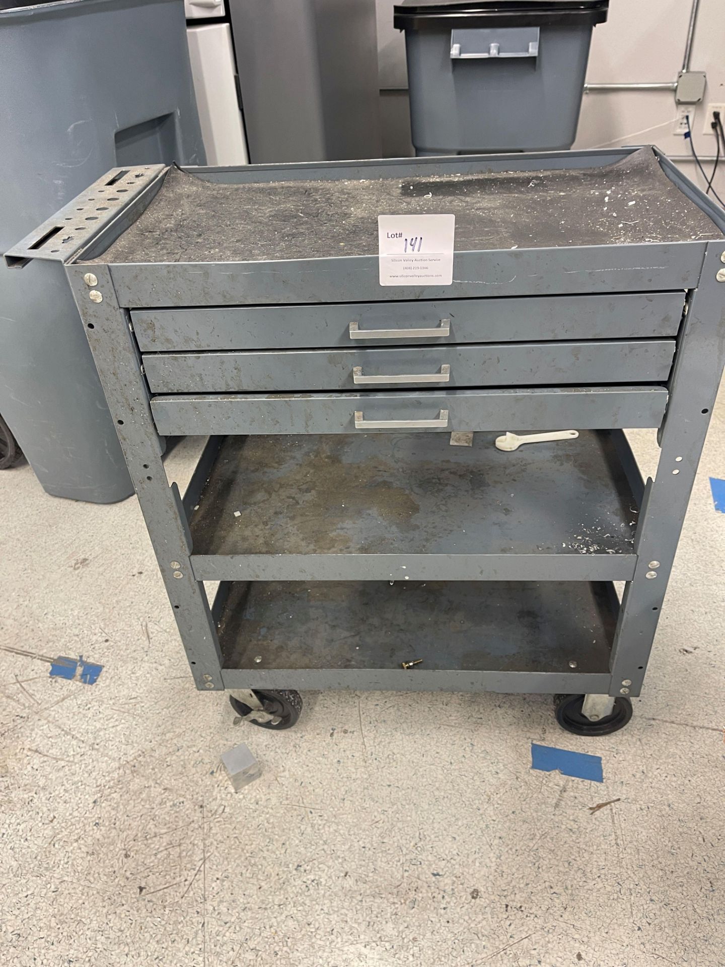 Metal cart with two shelves and three drawers on wheels