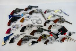A collection of cap guns, toy guns, handcuffs.