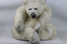 Soft Sensations bear by PMS International - A large plush white bear in sleeping position with what