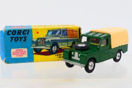 Corgi - A boxed Land Rover 109" in dark green with cream canopy and early style metal tow hook.