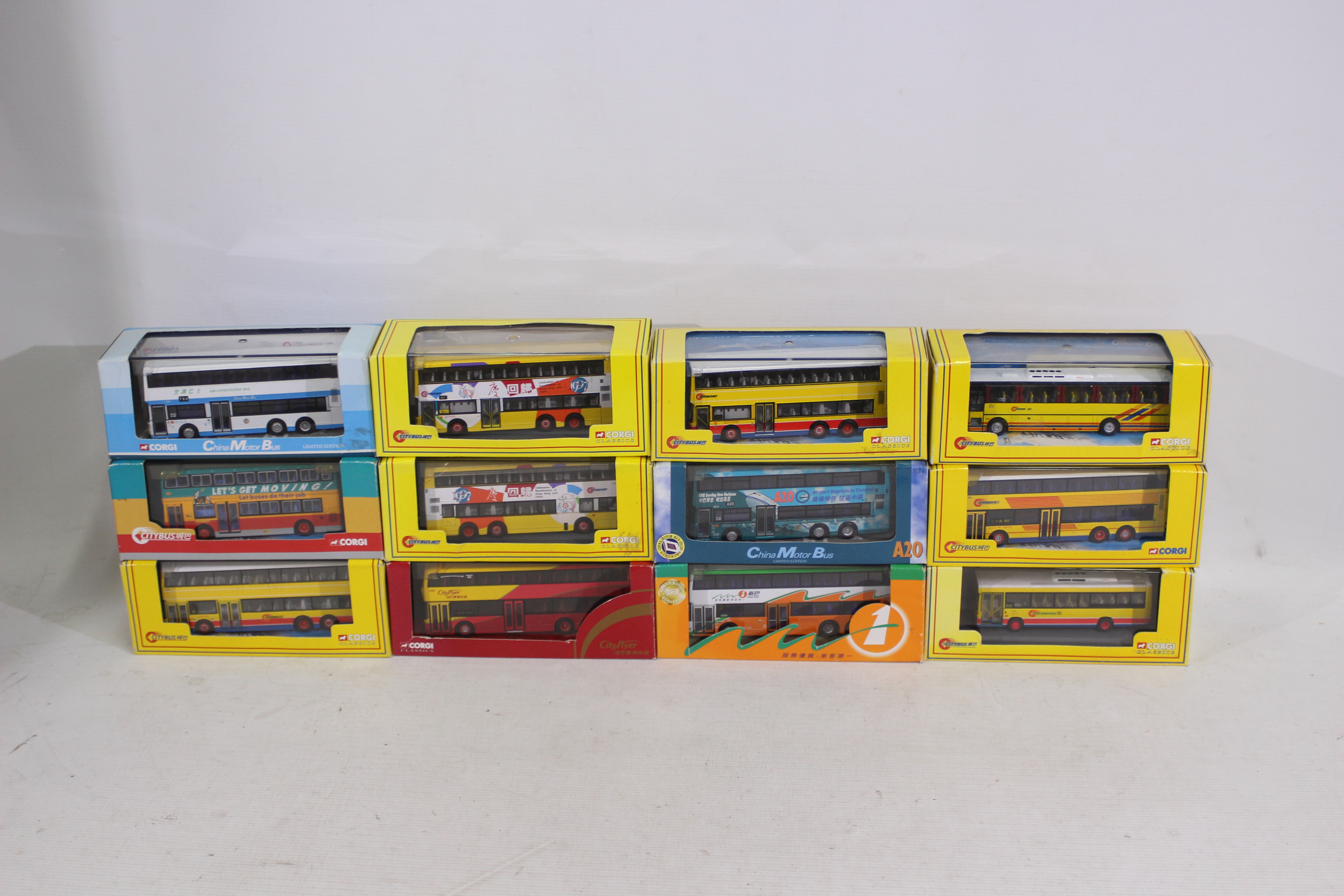 Corgi - A collection of twelve Corgi busses in display cases.