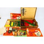 Meccano - A vintage wooden boxed Meccano set containing a quantity of red and green parts, wheels,