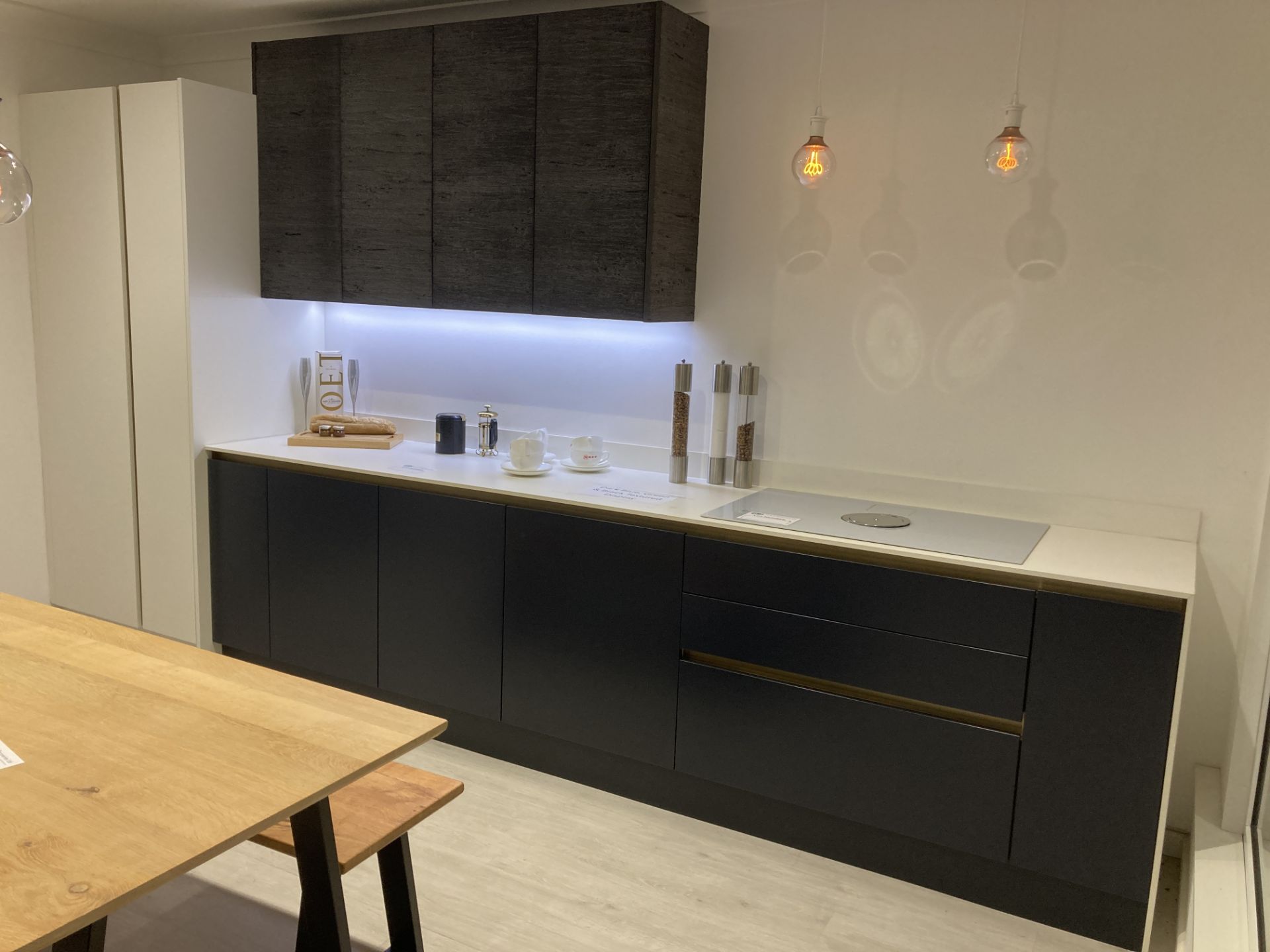 Dark blue, green and textured black display kitchen with appliance