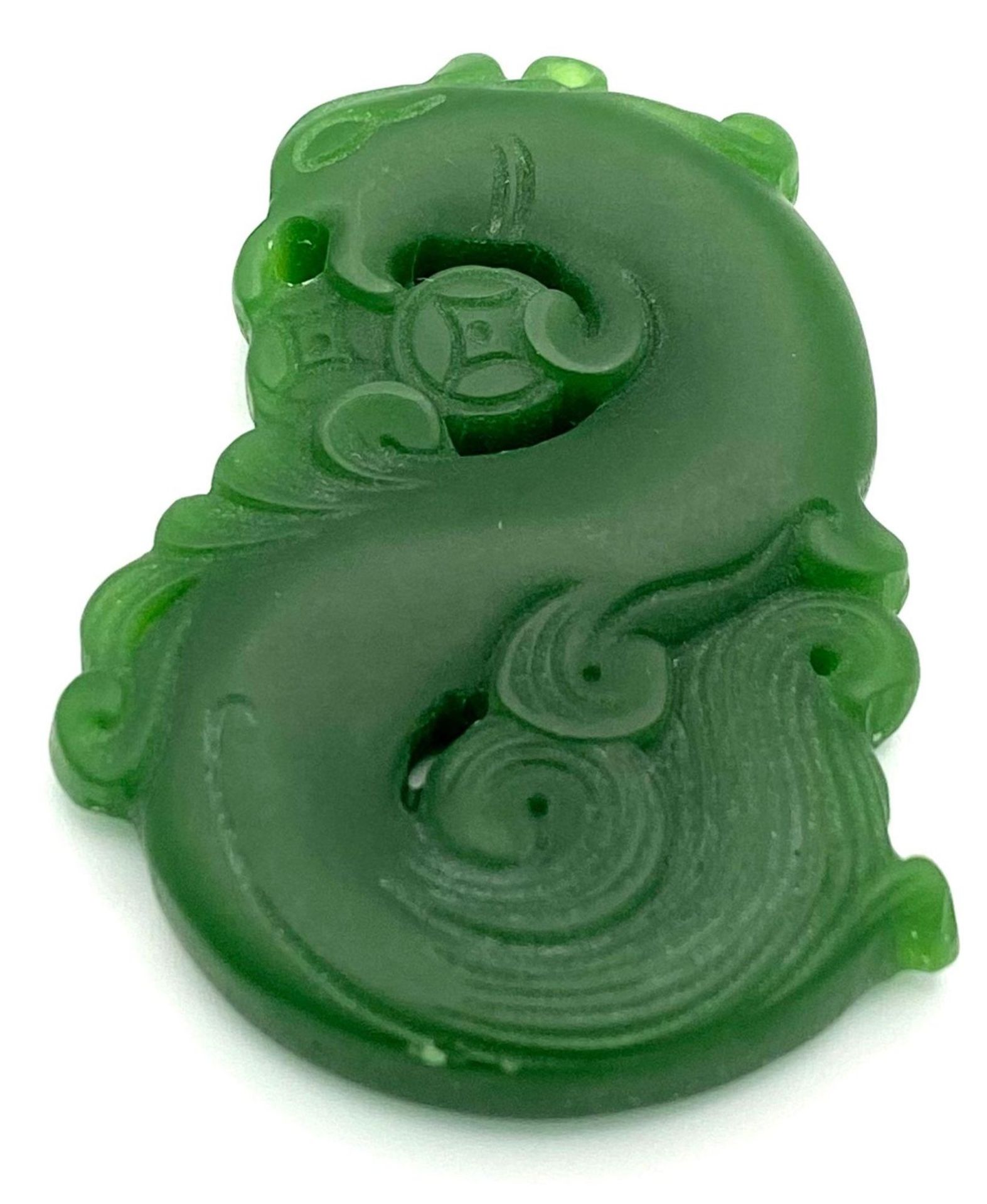 A Chinese Green Jade Swirling Dragon Pendant. 5cm