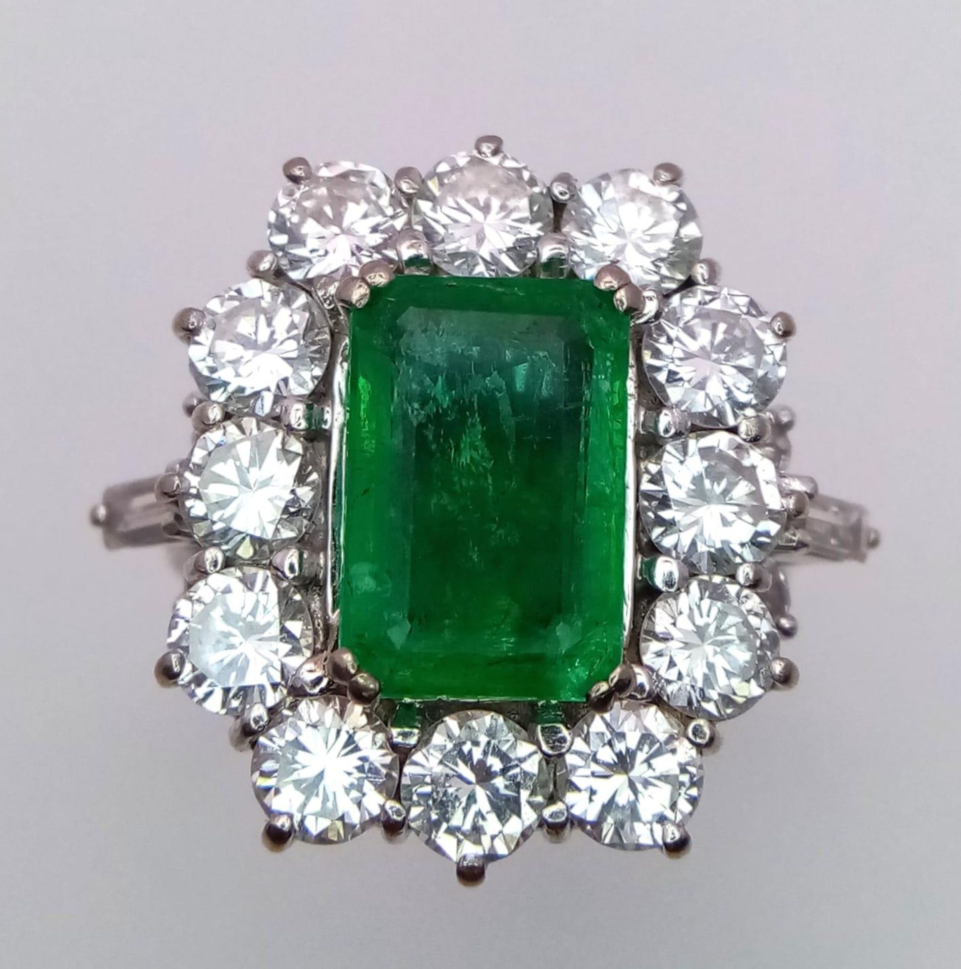 A Head-Turning 18K White Gold, Emerald and Diamond Ladies Dress Ring. Rectangular emerald with a