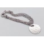 A sterling silver multi-strand bracelet with a round large charm with the word LOVE in many