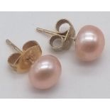A 9 K yellow gold pair of stud earrings with a natural round pink pearl each, total weight: 1.5 g.