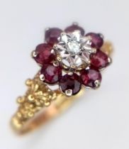 A Vintage 9K Yellow Gold Garnet and Diamond Floral Ring. Central diamond with a halo of garnets.