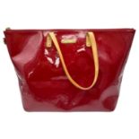 A Louis Vuitton Pomme D'Amour Monogram Vernis Bellevue PM Bag. Red patent leather exterior. Red