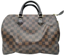 A Louis Vuitton Speedy Bag. Checked LV canvas exterior. Red textile interior. Comes with dust cover,