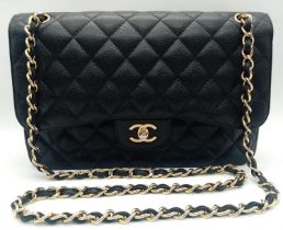 A Chanel Black Caviar Classic Double Flap Bag. Quilted pebbled leather exterior with gold-toned