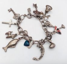 A vintage sterling silver charm bracelet with multiple charms such as wedding bell, cross, etc.