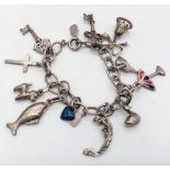 A vintage sterling silver charm bracelet with multiple charms such as wedding bell, cross, etc.