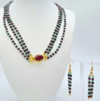 A three-row necklace, beautifully made of faceted ruby and emerald beads with a majestic ruby