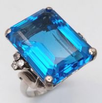 a large blue aqua stone flanked by 6 small diamonds and set in platinum . 14GMS SIZE o