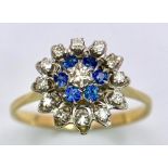 An 18 K yellow gold ring with a cluster of diamonds and blue sapphires. Ring size: O, weight: 2.9 g.