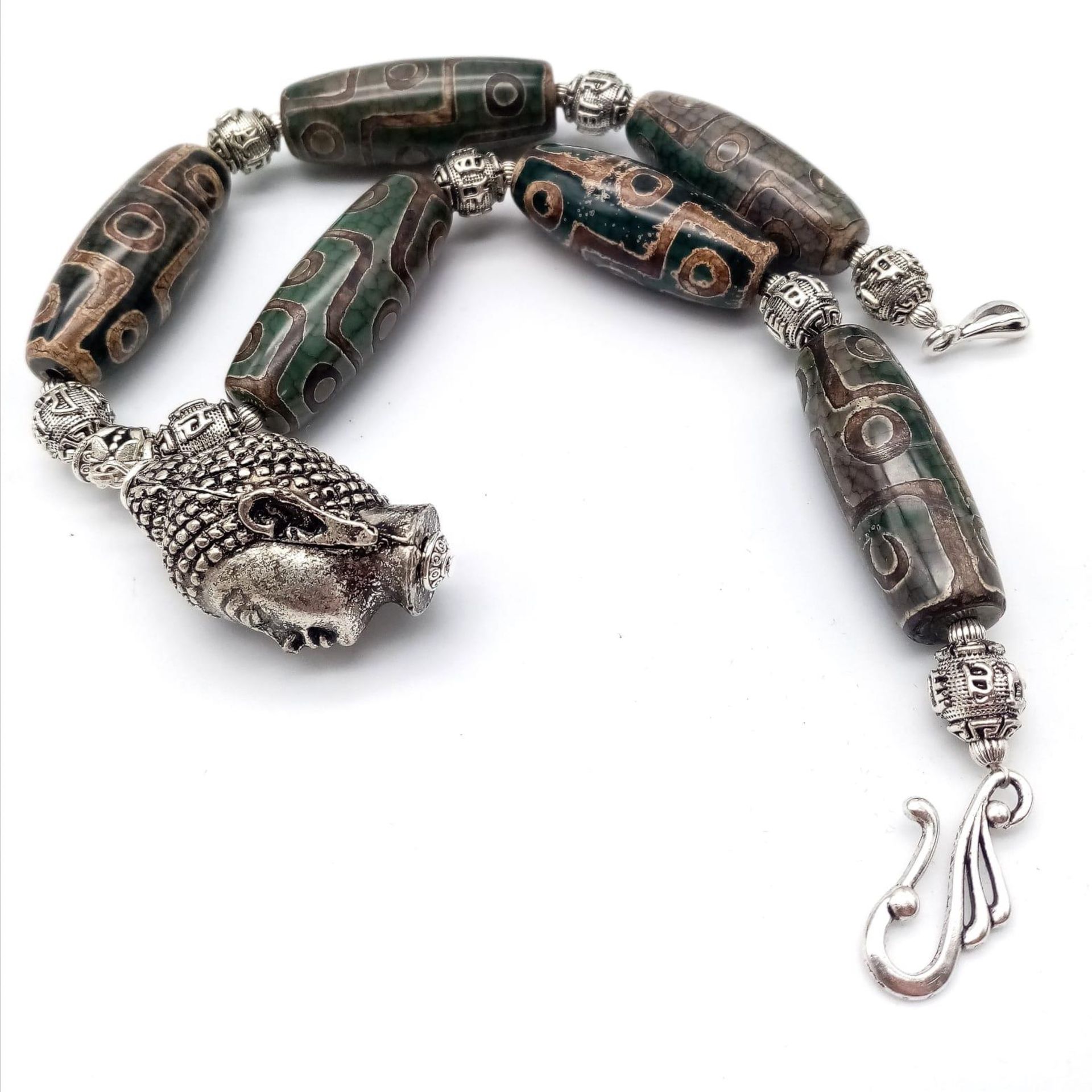 A Tibetan treasure: a nine eyed, large DZI beaded necklace and earrings set with a young Buddha head - Image 3 of 7
