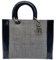 A Christian Dior - Lady Dior Bag. Canvas and black patent leather exterior. Silver tone hardware.