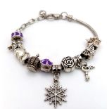 A tested sterling silver bracelet with ten silver charms, total weight: 30.9 g.