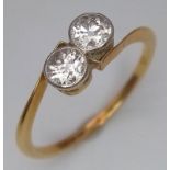 An 18 K yellow gold ring with a pair of two quality round cut diamonds (total 0.60 carats appr),