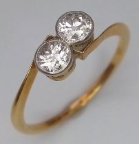 An 18 K yellow gold ring with a pair of two quality round cut diamonds (total 0.60 carats appr),