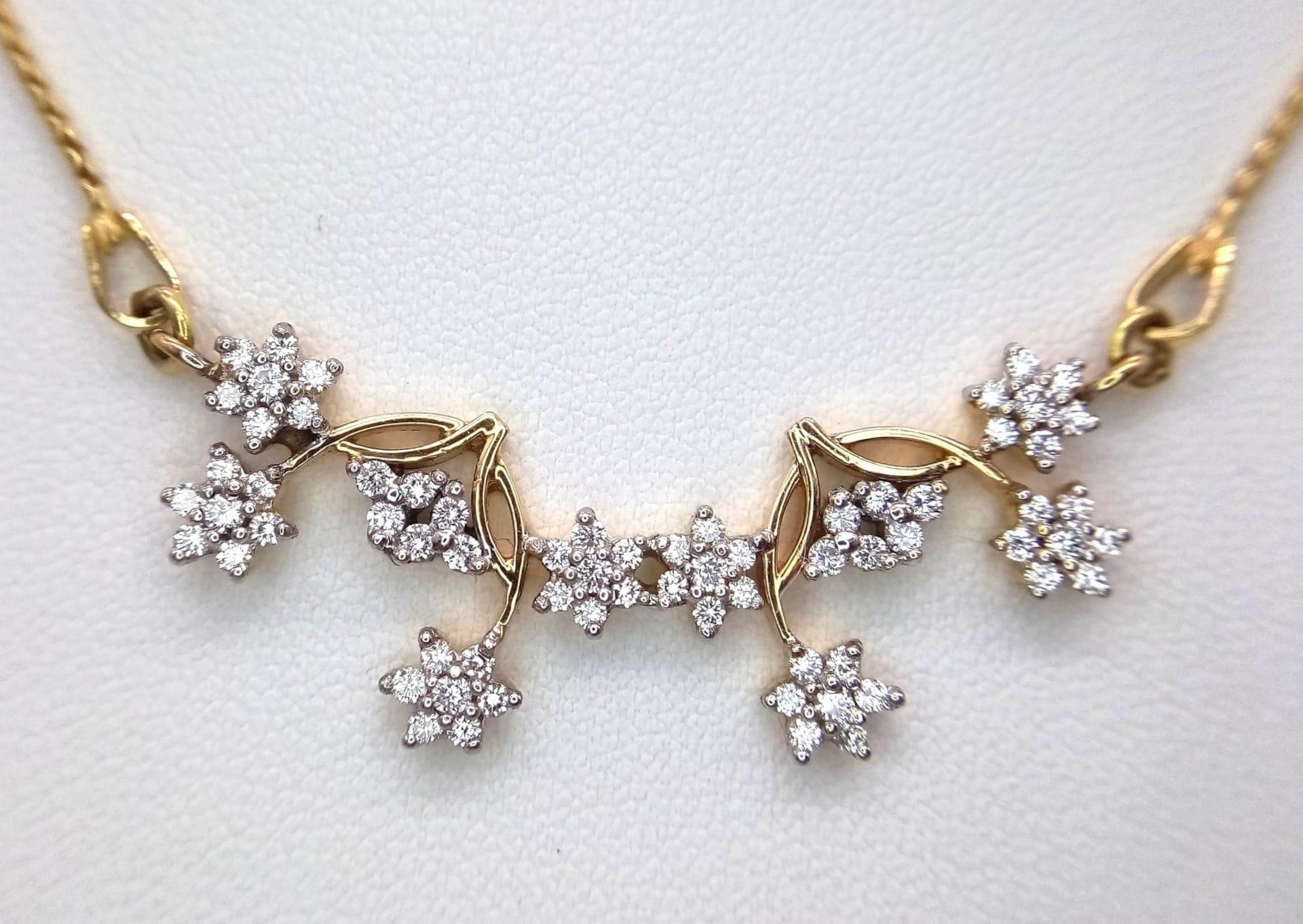 An elegant 18 K yellow gold necklace with with a flower design loaded with diamonds (0.70 carats),