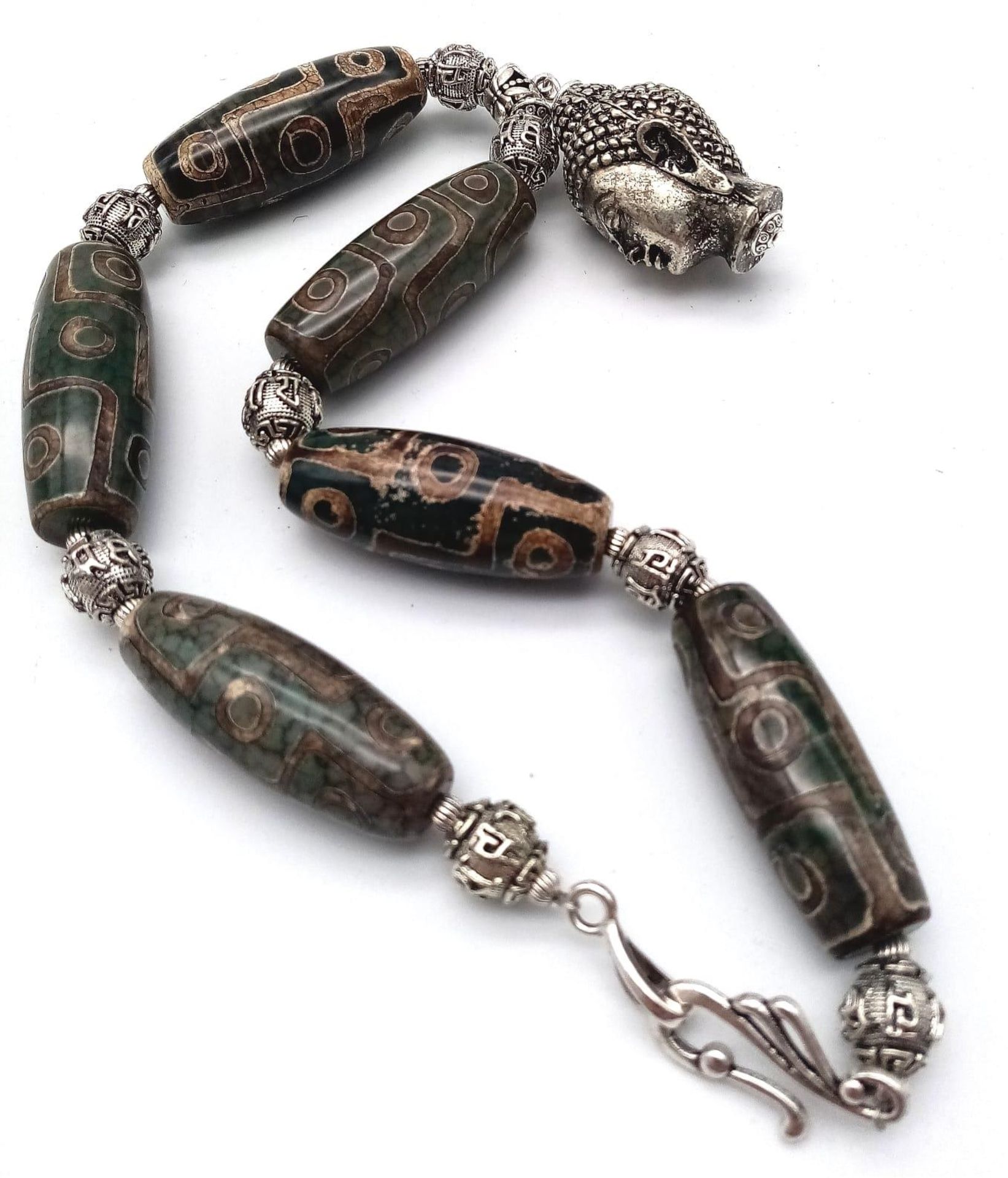 A Tibetan treasure: a nine eyed, large DZI beaded necklace and earrings set with a young Buddha head - Image 4 of 7