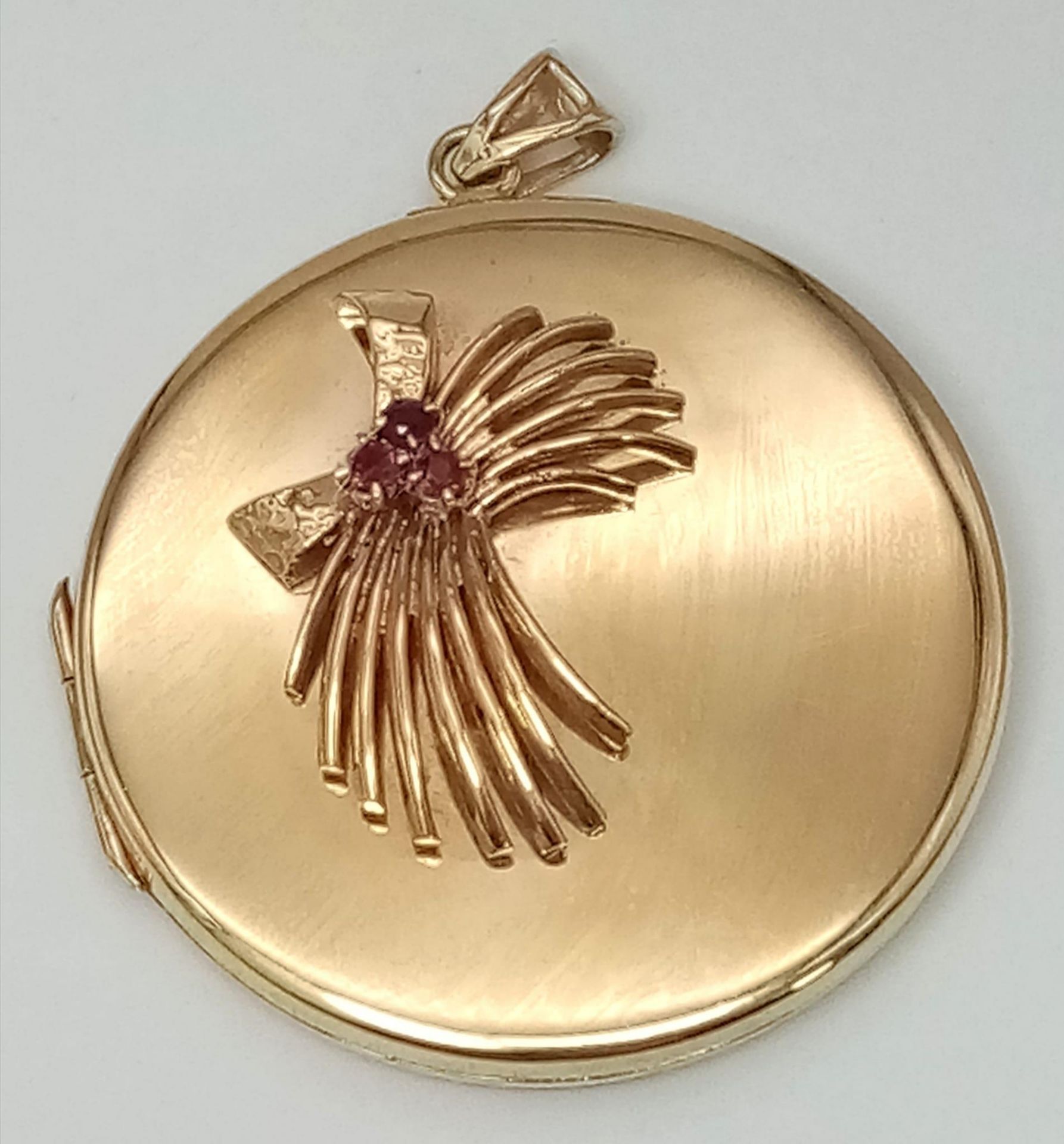 A SOLID 9K GOLD LOCKET STYLE PENDANT WITH GARNET DECORATION . 20.4gms 4.5cms DIAMETER 14954